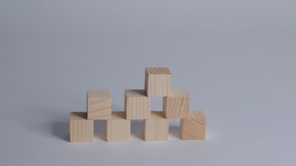 Рука влаштовує дерев'яний куб у вигляді сходів. Процес успішного зростання бізнес-концепції на білому тлі, копіювання простору. Крупним планом Повільний рух . — стокове відео
