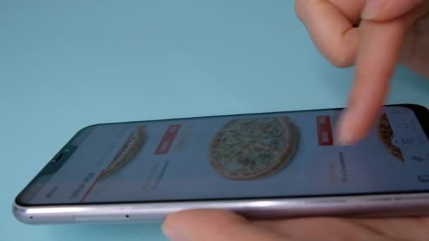 Russland, moskau - januar 2020. frau bestellt pizza über online lieferdienst mit smartphone. Nahaufnahme. Frau bestellt Lebensmittel im Online-Shop per Smartphone — Stockvideo