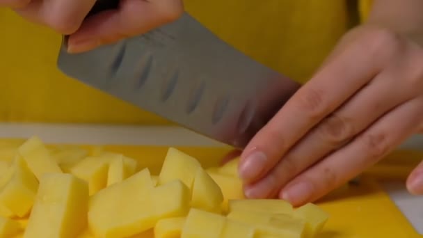 Primer plano de la mano con cuchillo de corte vegetal fresco. Mujer cortando papas en un primer plano de tabla de cortar blanco . — Vídeo de stock
