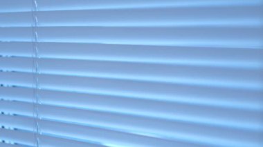 Kadın eli açık, perdeler kapalı.