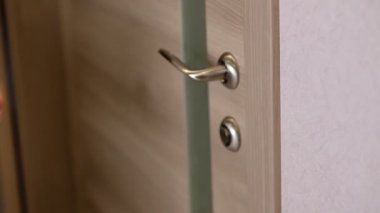 Kadınlar ya kapı kolunu açar ya da kapıyı açar.