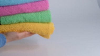 Yakın plan çekimler, temiz banyo havlularını çarşafın üstüne koyuyor. Oda hizmetçisi otel odasını temizliyor.