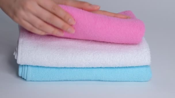 Close-up van de handen zetten stapel verse badhanddoeken op het laken. Roomservice schoonmaakster hotelkamer macro — Stockvideo