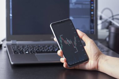 Akıllı telefonlardan hisse senedi alım satımı yapan bir kadın. İş konsepti. İş kadını eliyle akıllı telefondan ticaret yapmak