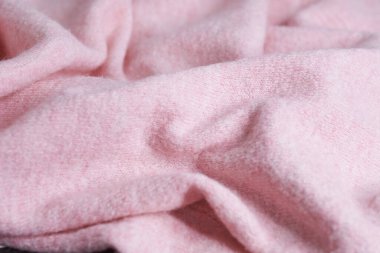Büyük kıvrımlı kaşmirden yapılmış yumuşak örülmüş kumaş, giysi ayrıntıları. pembe kumaş dokusu