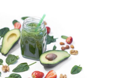 Sağlıklı vejetaryen yeşil ıspanaklı meyve suyu. Beyaz arka planda ıspanak ve avokado. Yavaş çekimde pişirmeye yakın.