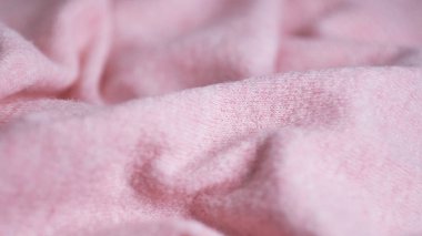 Büyük kıvrımlı kaşmirden yapılmış yumuşak örülmüş kumaş, giysi ayrıntıları. pembe kumaş dokusu