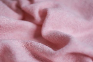 Büyük kıvrımlı kaşmirden yapılmış yumuşak örülmüş kumaş, giysi ayrıntıları. pembe kumaş dokusu