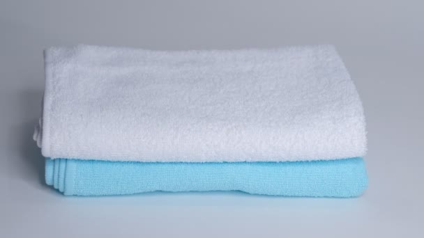 Primer plano de las manos poniendo pila de toallas de baño frescas en la sábana. Servicio de habitaciones limpieza limpieza habitación de hotel macro — Vídeos de Stock