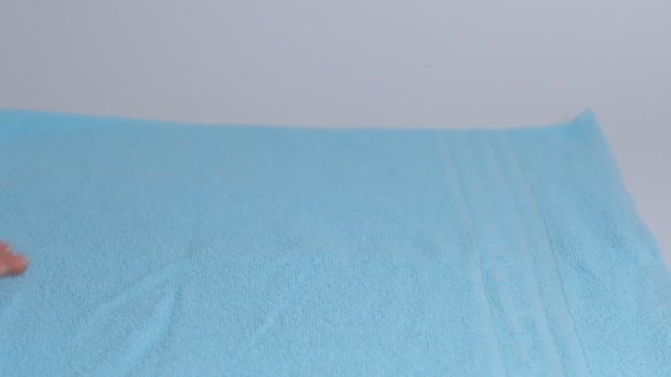 ベッドのシートに新鮮なバスタオルのスタックを置く手のクローズアップ。ルームサービスメイドクリーニング｜ホテルの部屋マクロ — ストック動画