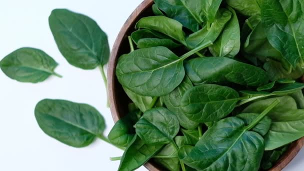 Top view of spinach in a wooden bowl on white table. Close up of cooking in slow motion. — Stock Video
