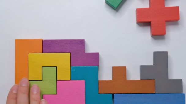 Gros plan Mouvement lent. Pièce de main tenant de puzzle bloc en bois. empilement de cubes de bois. Concept de pensée logique complexe et intelligente . — Video