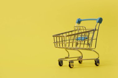 Sarı arka plandaki alışveriş arabasında fotokopi alanı var.