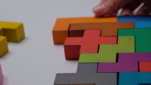 Sluiten Slow motion. Een stuk houten blokpuzzel. stapelen van houten blokjes. Concept van complex en slim logisch denken. — Stockvideo