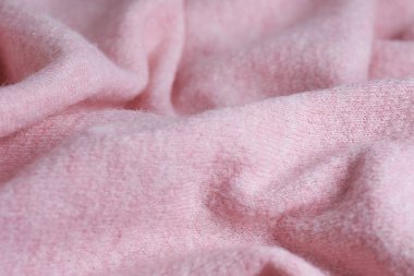 Büyük kıvrımlı kaşmirden yapılmış yumuşak örülmüş kumaş, giysi ayrıntıları. pembe kumaş dokusu