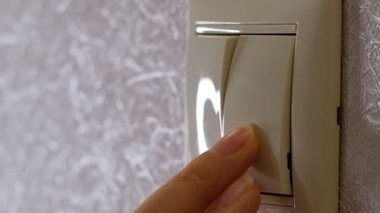 Işık kapalı - kadın el düğmesi açık gri bir duvarın üzerinde, yan görünüm