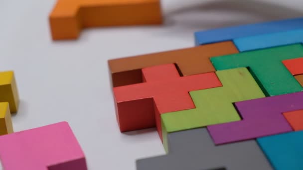 Primo piano Rallentatore. Mano tenendo pezzo di puzzle blocco di legno. impilamento cubo di legno. Concetto di pensiero logico complesso e intelligente . — Video Stock