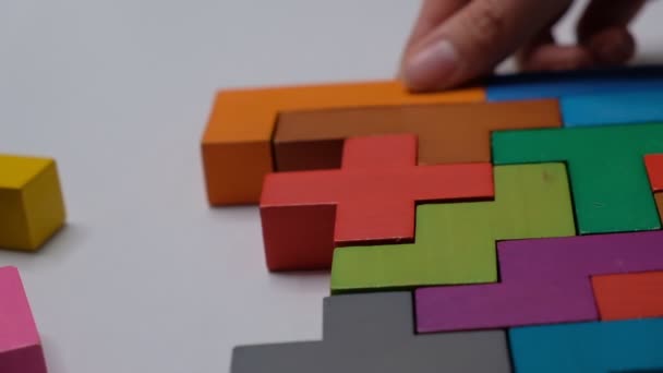 Sluiten Slow motion. Een stuk houten blokpuzzel. stapelen van houten blokjes. Concept van complex en slim logisch denken. — Stockvideo