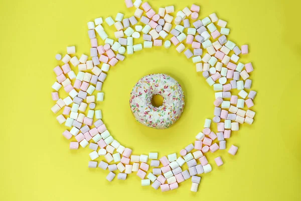 Donut in a round marshmallow frame on a yellow background. top view photo — Stock Photo, Image