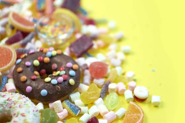 Bir sürü renkli şeker var. Lezzetli İştah açıcı Parti Aksesuarları Mutlu Yıllar Tatlı Şeker Şeker Lolipopu Parlak Arkaplan Yatağında — Stok fotoğraf