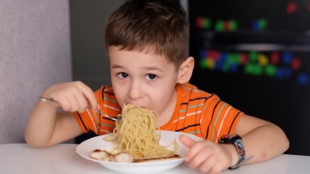 Child playing with pasta at dining table. messy face eating. sauce and kid. boy eats pasta noodles sitting in nursery cafe. Happy child eating healthy organic and vegan food in restaurant. — ストック動画