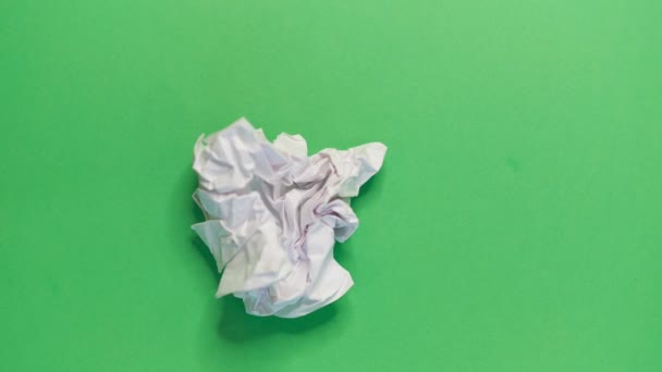 Stop motion video animation white paper wrinkles making a paper ball on a green background — Stock Video