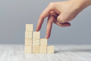 el parmak merdiven gibi yığılmış ahşap blok üzerinde yürümek. basamaklarda yükselir. İş geliştirme ve büyüme kavramı.