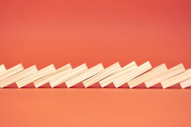 Tahta domino taşı seti. Çözüm ve domino etkisi kavramı. Kırmızı arka planda izole edilmiş. Biraz odaklanma kaybı ve yakın çekim. Boşluğu kopyala.