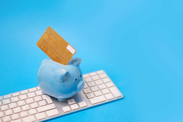 копилка и куча кредитных карт, финансовые отходы. Реструктуризация долга, финансовые затруднения, пересмотр своих просроченных долгов. на синем фоне
