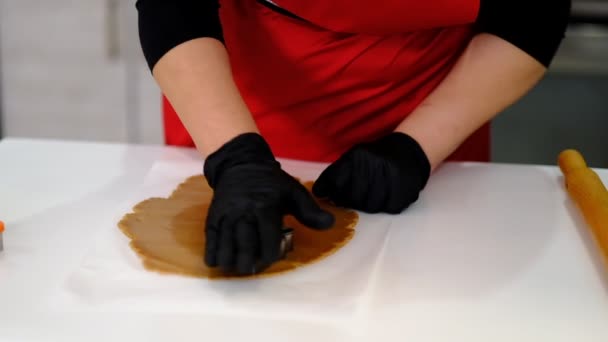 Chef skär degen för att förbereda kakor. Kvinnlig bagare skär degen i form av löv. Konfekten på jobbet. Friska bakning koncept — Stockvideo