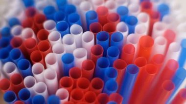 Renkli kokteyl plastik pipetleri beyaz renkli arka planda döner. Yavaş Çekim videosu