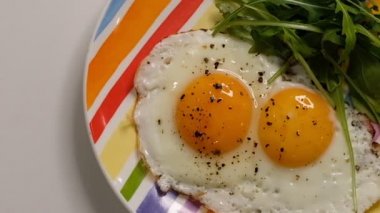 Tabakta iki yumurta. Tahta masaya kızarmış yumurta tabağı koymak. Beyaz porselen tabağı sahanda yumurtayla kapat. Geleneksel kahvaltı yemeği