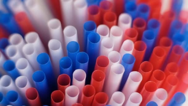 Colored cocktail plastic drinking straws rotates on white color background. Shot Slow Motion video — Stock Video