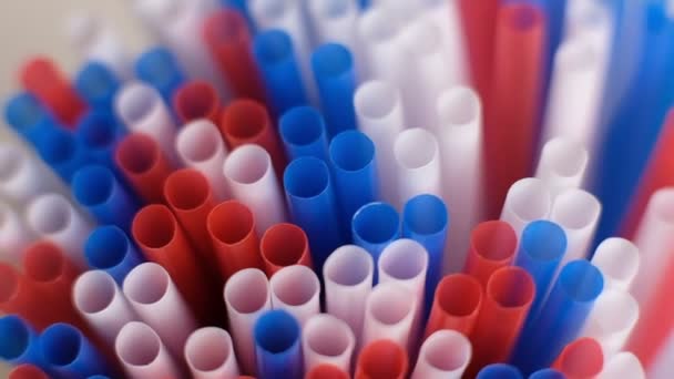 Colored cocktail plastic drinking straws rotates on white color background. Shot Slow Motion video — Stock Video