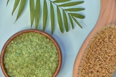 Masaj kil tozu, yüz maskeleri, banyo tuzu, havlu, mavili tereyağı mavi masa arkasında..