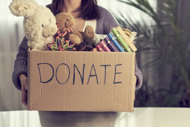 Donation box with children toys. woman collects toys for charity.