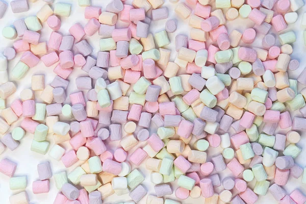 Bovenaanzicht van Pastel gevormde Marshmallow snoepjes met wat gestrooid op de lichtwitte tafel — Stockfoto