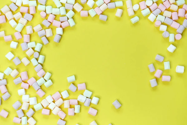 Vista superior de doces de marshmallow em forma de pastel com alguns dispersos na mesa amarela pálida — Fotografia de Stock