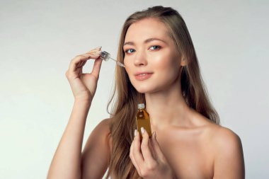 Beyaz üzerinde deri serumu tedavisi uygulayan güzel bir model. Spa, cilt bakımı ve sağlık. Yakın çekim, kopyalanma alanı