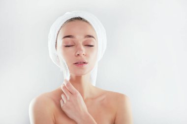 Spa tedavileri. Deri bakımı konsepti. Temiz ciltli genç bir kadın. Güzel genç kız. Gözleri kapalı çekici bir kız. Yüzünde beyaz bir tüy olan güzel bir kadın..