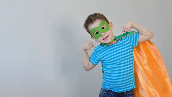 Un ragazzino che fa il supereroe. Ragazzo in costume da supereroe. bambino felice. maschera verde, concetto di cura della natura — Foto Stock