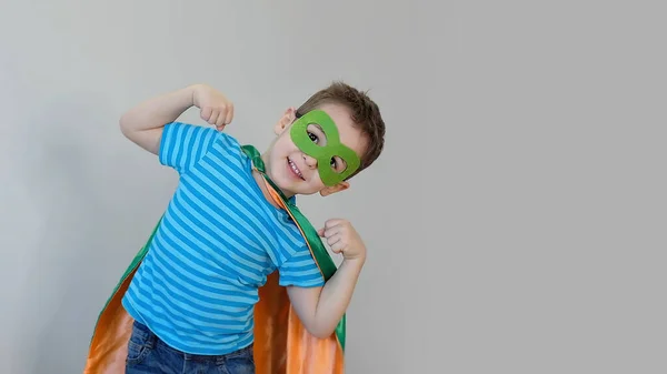 Un niño jugando a ser un superhéroe. Niño con un disfraz de superhéroes. niño feliz. máscara verde, concepto de cuidado de la naturaleza —  Fotos de Stock
