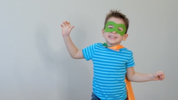Ritratto di un ragazzo forte e sicuro di sé in un costume da supereroe Guardando la telecamera che mostra bicipiti. concetto di successo. infanzia felice. 4k video — Video Stock