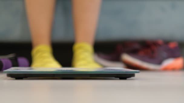 Vrouw met grappige gele sokken op schaal op de vloer. doet hardloopschoenen aan om te gaan hardlopen of te trainen — Stockvideo