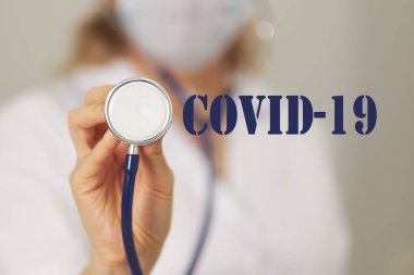 Kurabiyelerde steteskoplu COVID-19 yazan bir doktor. Mavi arkaplanlı Coronavirus 2019-NCoV romanından. Virüs Salgını Koruma Konsepti
