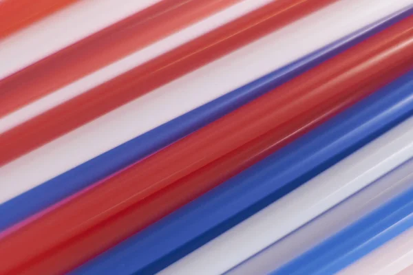 Colored cocktail plastic drinking straws rotates on white color background.