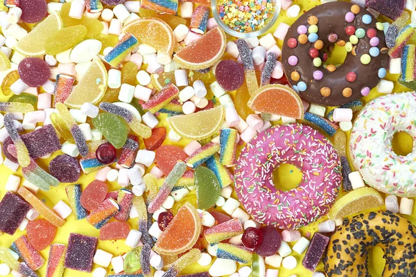 Bir sürü renkli şeker var. Lezzetli İştah açıcı Parti Aksesuarları Mutlu Yıllar Tatlı Şeker Şeker Lolipopu Parlak Arkaplan Yatağında — Stok fotoğraf