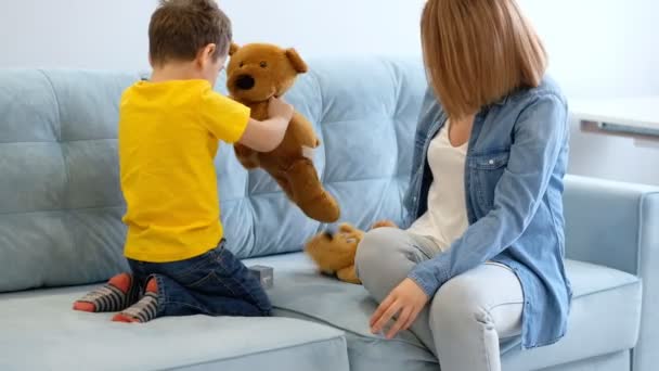 Madre e figlio giocano con il giocattolo sul divano. Divertitevi insieme. mamma sta cercando di entrare in contatto con il suo figlio iperattivo — Video Stock