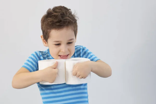 Ativo menino brincando com papel higiênico no filtro retro, garoto olhando através do rolo de vaso sanitário, abraços da criança um monte de papel higiênico, conceito de cuidados de saúde infantil — Fotografia de Stock