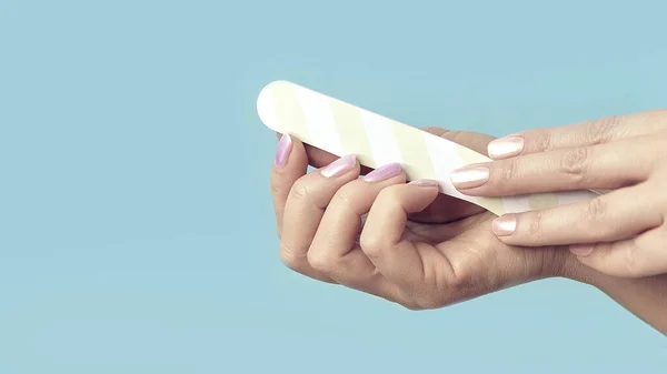 De cerca la foto de la mujer haciendo manicura con la lima de uñas . —  Fotos de Stock